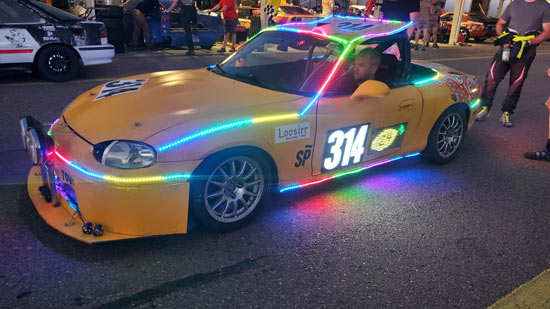 Our 1999 Miata in the pits showing off its fancy lights at a 24 Hours of Lemons race in September 2023